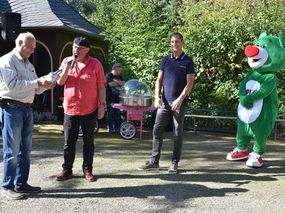 Moderator Ralf Bäßler überreichte dem Fördervereinschef Prof. Dr. Klaus Eulenberger eine Spendenbox, die bei den zurückliegenden Veranstaltungen im Stadtpark von den Besuchern gefüllt wurde.